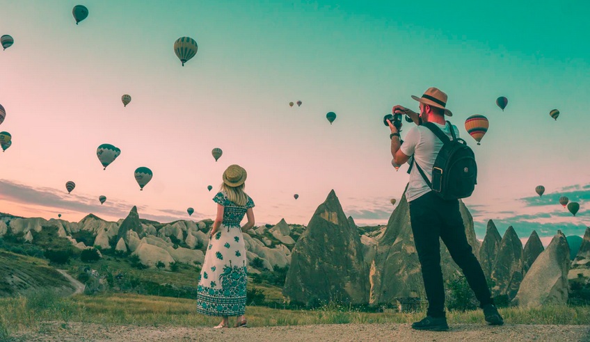 man taking photo of hot air balloons
